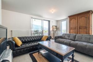 ein Wohnzimmer mit einem Sofa und einem Tisch in der Unterkunft Suite Kandinsky Furnished flat in Aix-les-Bains