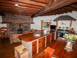 a living room with a stone fireplace and a kitchen at Windmill On The Farm in Ormskirk