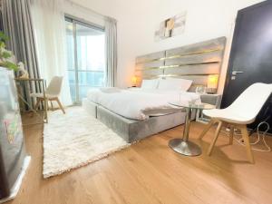 1 dormitorio con 1 cama, mesa y sillas en Luxury Room with Marina view close to JBR Beach and Metro with Shared Kitchen en Dubái