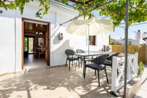 a patio with a table and chairs and an umbrella at Casa Monte in Theológos