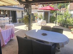 un patio con mesa, sillas y sombrilla en Maison du bonheur en Pouilly-en-Auxois