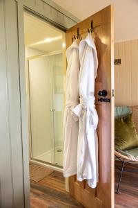 a bathroom with towels hanging on a door at The Hide at Woodside in St. Andrews
