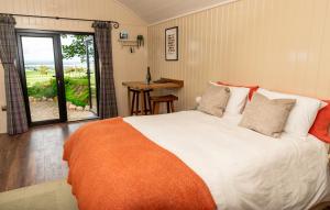 1 dormitorio con cama, mesa y ventana en The Hide at Woodside en St Andrews