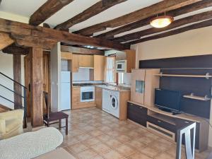 a kitchen with a table and a tv in a room at La casa de Omi in Camaleño