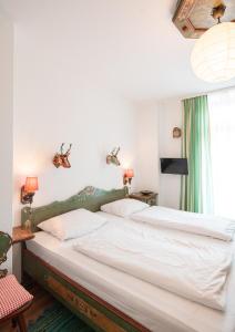1 dormitorio con 2 camas blancas y ventana en Pension Bellevue, en Múnich