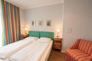 Habitación de hotel con cama y silla en Pension Bellevue, en Múnich