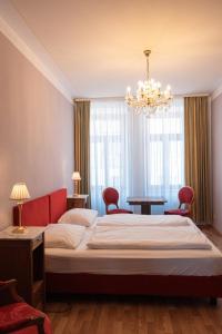 una camera con un grande letto e un lampadario a braccio di Pension Bellevue a Monaco