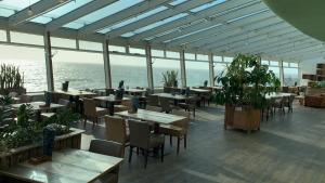 un restaurant avec des tables et des chaises et l'océan dans l'établissement De Pier Suites, à Scheveningen 23 autres photos