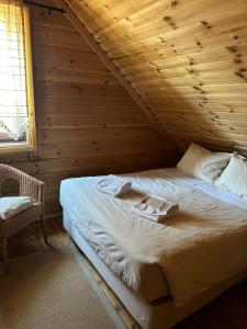 ein Schlafzimmer mit einem Bett in einer Holzhütte in der Unterkunft Chalé Inn Star in Penhas da Saúde