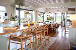 uma sala de jantar com uma mesa longa e cadeiras em Villa sublime con piscina climatizada y vistas em Prellezo