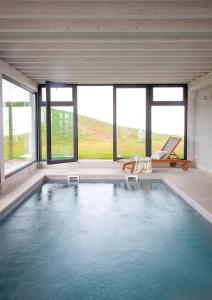 uma grande piscina numa casa com janelas em Villa sublime con piscina climatizada y vistas em Prellezo