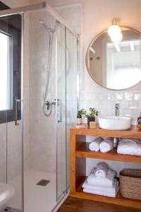 uma casa de banho com um chuveiro, um lavatório e um espelho. em Villa sublime con piscina climatizada y vistas em Prellezo