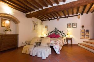 a bedroom with a bed and two chairs at Il Pozzo in San Gimignano