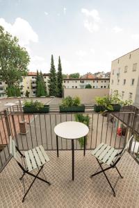 una mesa, 2 sillas y una mesa en el balcón en Pension Bellevue, en Múnich