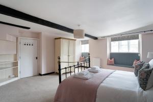 1 dormitorio con 1 cama grande en una habitación en Moreton High Street - Sleeps 10, with private garden en Moreton in Marsh
