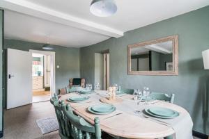 a dining room with a table with chairs and a mirror at Moreton High Street - Sleeps 10, with private garden in Moreton in Marsh