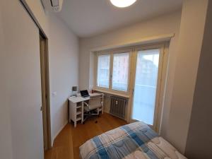 een slaapkamer met een bed, een bureau en een raam bij Appartamento di design con terrazza privata in Rome