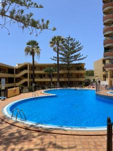 een groot blauw zwembad in een gebouw bij Torres Del Sol , Las Americas , cute apartment in Arona