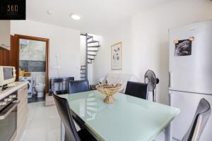 uma cozinha e sala de jantar com uma mesa e um frigorífico em Spacious, 1BR duplex off UNI/Hospital with WIFI by 360 Estates em Msida