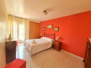 ein Schlafzimmer mit roten Wänden und ein Bett in einem Zimmer in der Unterkunft Vistas al mar con Aire Acondicionado y Parking - by Aloha Palma in Águilas