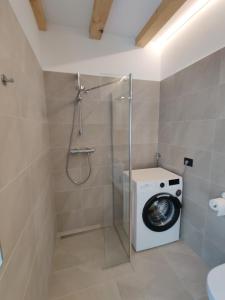 uma casa de banho com uma máquina de lavar roupa e um chuveiro em Casa Venere em Ospedaletto