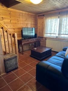 ein Wohnzimmer mit einem Sofa und einem TV in der Unterkunft Chalé Inn Star in Penhas da Saúde
