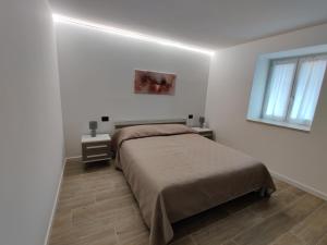 a white bedroom with a bed and a window at Casa Venere in Ospedaletto