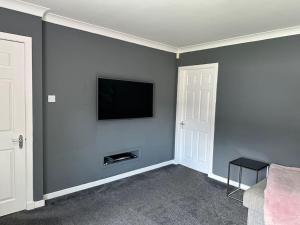 ein Wohnzimmer mit einem Flachbildfernseher an der Wand in der Unterkunft Family friendly detached 2 bed home, Loch Lomond in Bonhill