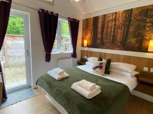 - une chambre avec un lit et des serviettes dans l'établissement Hare Lodge with Hot Tub, à Cupar