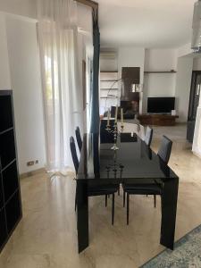 a dining room with a black table and chairs at Eur Centro lux apartment con camino in Rome