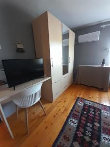een woonkamer met een bureau en een bed bij Soba Lavanda in Kladovo