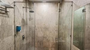 a shower in a bathroom with a glass door at The Corum View Hotel in Bayan Lepas