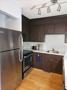 La cuisine est équipée d'un réfrigérateur en acier inoxydable et d'un évier. dans l'établissement Beautiful Home Away From Home, à Winnipeg