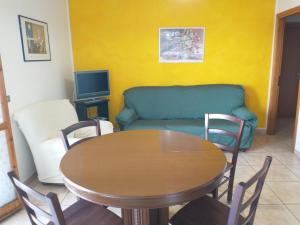 un soggiorno con tavolo e divano di CASA BLU a Porto SantʼElpidio