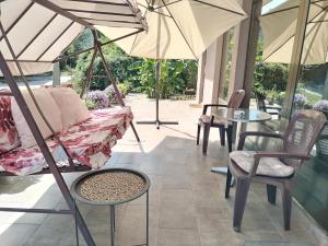 a patio with chairs and tables and umbrellas at Guest House Dimitrije in Niška Banja
