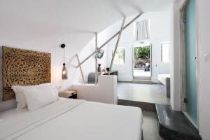 a bedroom with a white bed and a living room at The Museum Project Oia in Oia +129 photos