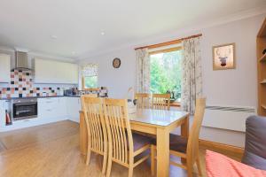 a kitchen and dining room with a table and chairs at Honeysuckle, Colvend in Rockcliffe