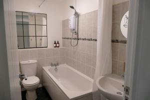 a bathroom with a toilet and a tub and a sink at Home in Longwell Green in Warmley
