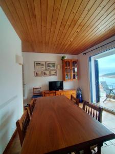 una sala da pranzo con un grande tavolo in legno e una grande finestra di Patxei a Tamariu