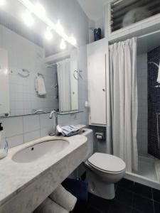 bagno bianco con lavandino e servizi igienici di Patxei a Tamariu