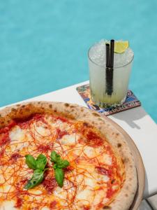 a pizza sitting on a table next to a drink at Grand Hotel Bristol Spa Resort, by R Collection Hotels in Rapallo