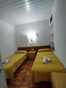 Habitación con 3 camas en una habitación con luz en Patxei en Tamariu