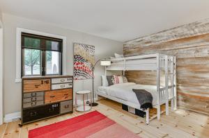 1 dormitorio con litera y pared de madera en 454 Hotel du Lac - Cozy 2BR Condo w Stunning Mountain & Lake Views, en Mont-Tremblant