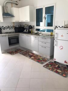 a kitchen with white appliances and two mats on the floor at Dream House in Houmt Souk