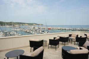 a patio with tables and chairs and a marina at Dolcemente Garni Hotel Superior in Izola