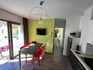 uma cozinha e sala de jantar com mesa e cadeiras em Gardesana Active Apartments em Malcesine