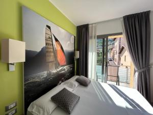 a bedroom with a bed with a large painting on the wall at Gardesana Active Apartments in Malcesine