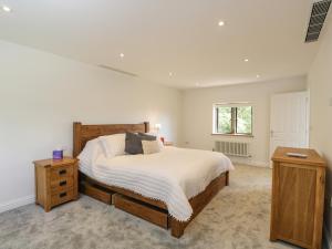 a bedroom with a large bed and a window at Paddock Barn in Chippenham