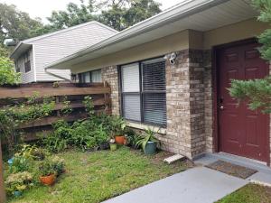 una casa con una porta rossa e una recinzione di Discover Luxury Condo Steps Away from Celebration Pointe and I-75! a Gainesville