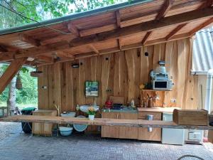 uma cozinha em madeira com um balcão e um micro-ondas em Jurta az erdő mellett dézsával-KERESZ-TANYA em Pilisszentkereszt